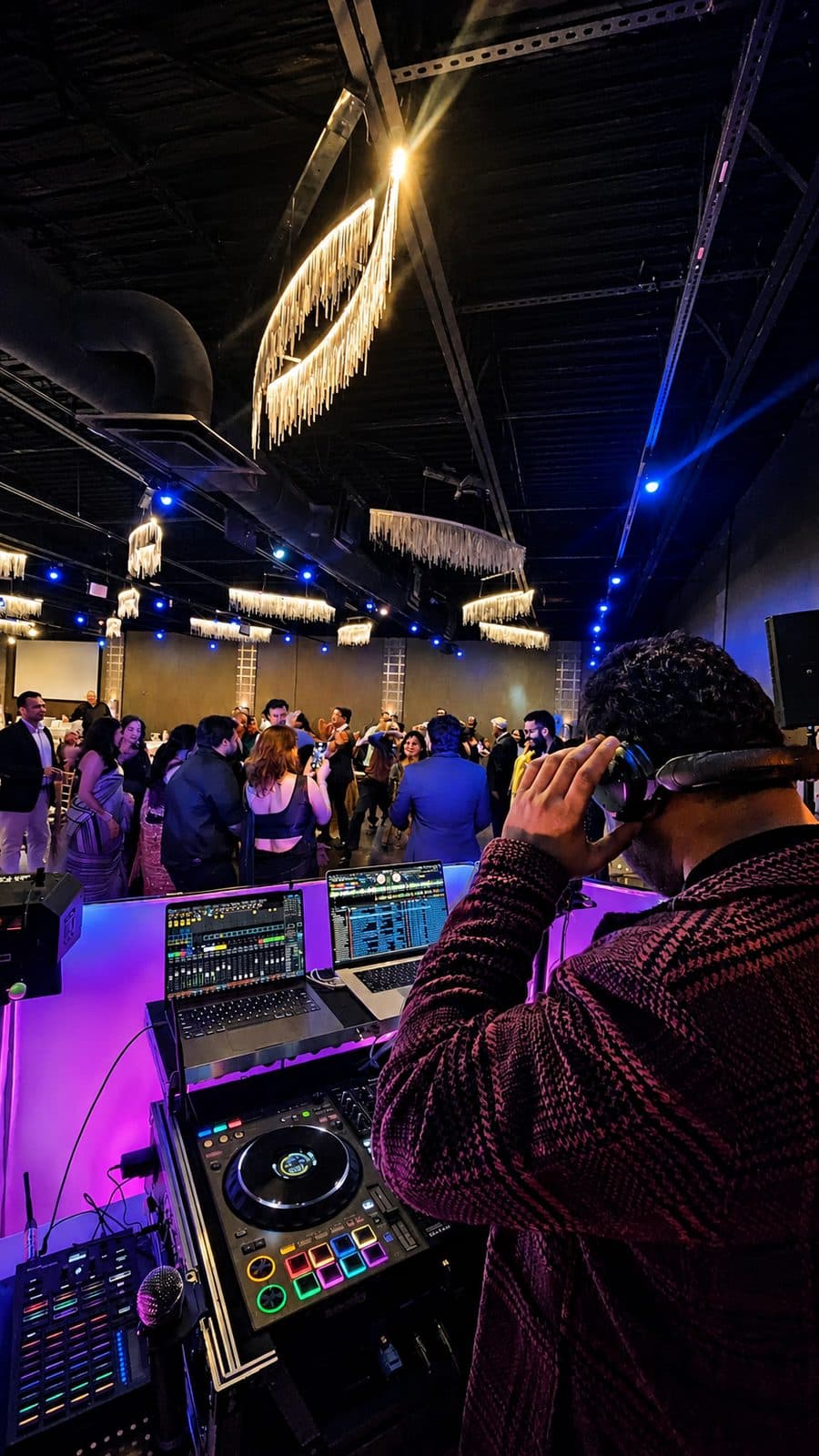 A Vyoma Productions DJ reading the crowd from the booth at a wedding reception